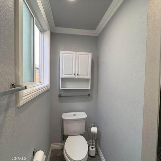 bathroom with ornamental molding and toilet