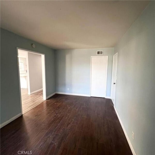 unfurnished room with dark hardwood / wood-style floors