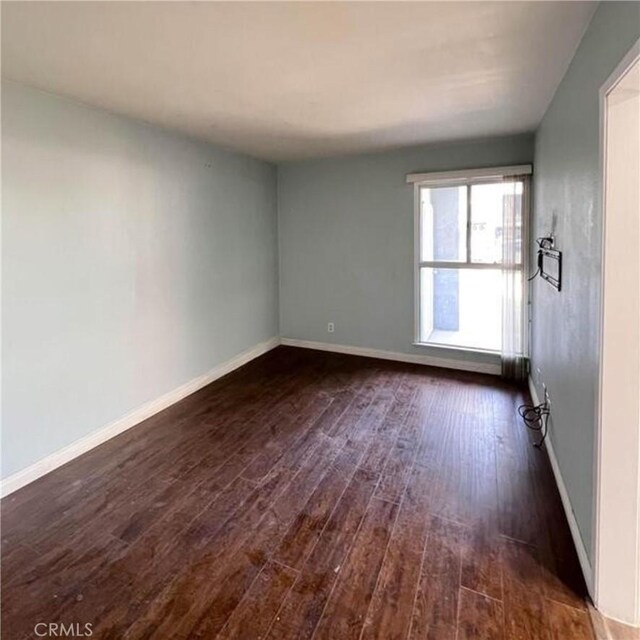 empty room with dark hardwood / wood-style flooring