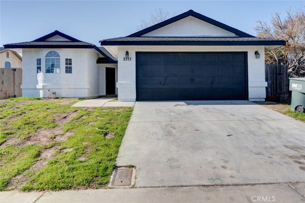 ranch-style house featuring a garage and a front yard