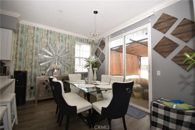 dining area with hardwood / wood-style flooring, ornamental molding, plenty of natural light, and an inviting chandelier