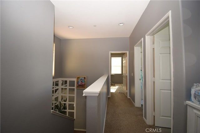 hall featuring dark colored carpet