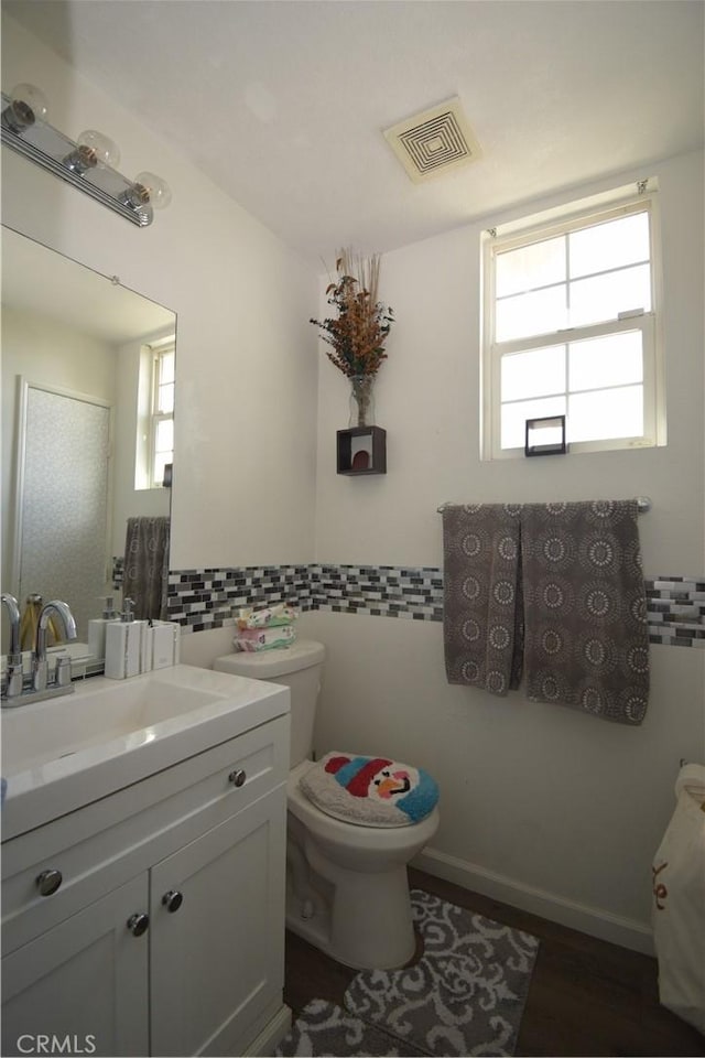 bathroom featuring tile walls, vanity, hardwood / wood-style flooring, and toilet