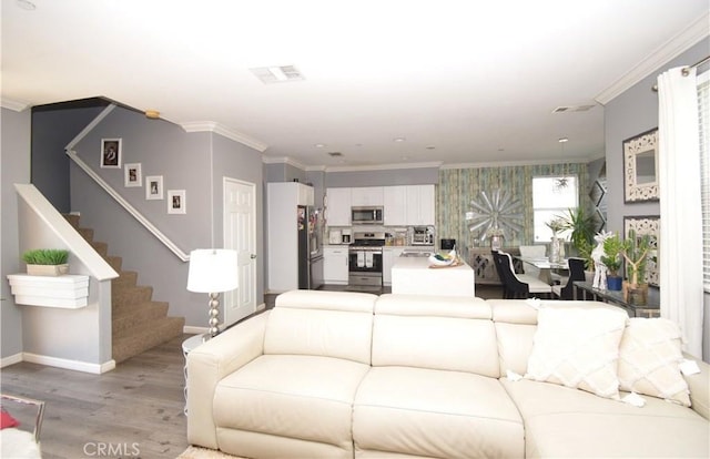 living room with ornamental molding and light hardwood / wood-style floors