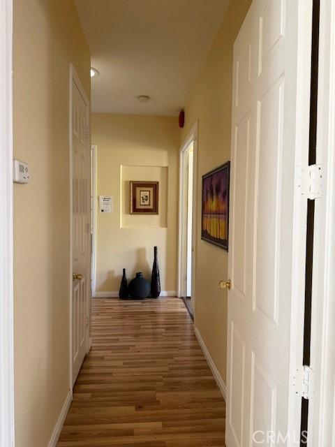 hallway with hardwood / wood-style flooring