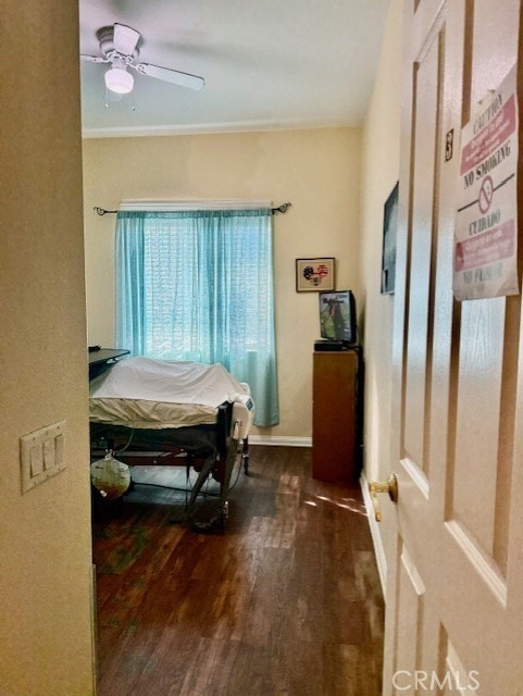 bedroom with crown molding, dark hardwood / wood-style floors, and ceiling fan