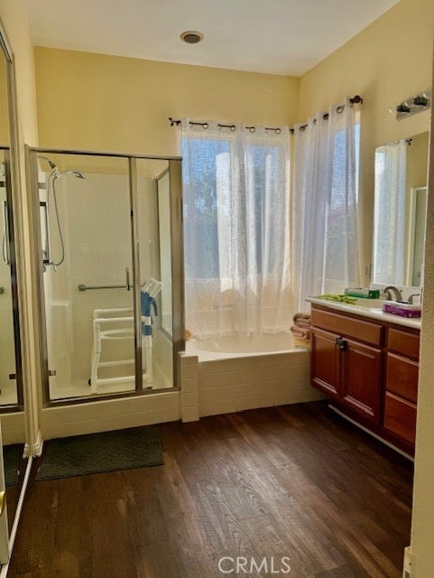 bathroom with wood-type flooring, plus walk in shower, and vanity