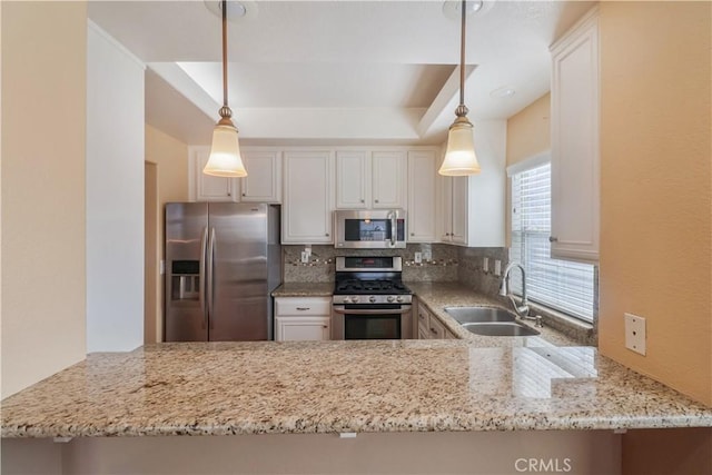 kitchen featuring light stone countertops, a peninsula, appliances with stainless steel finishes, a sink, and backsplash