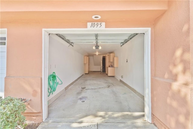 garage with baseboards and a garage door opener