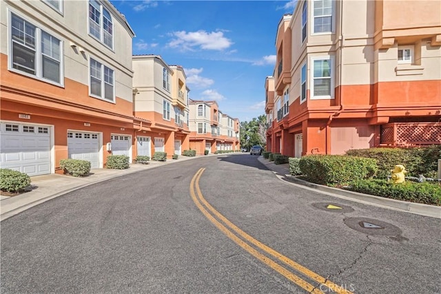 view of street with sidewalks, curbs, and a residential view