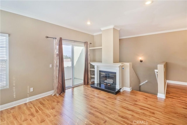 unfurnished living room with built in features, ornamental molding, and light hardwood / wood-style flooring