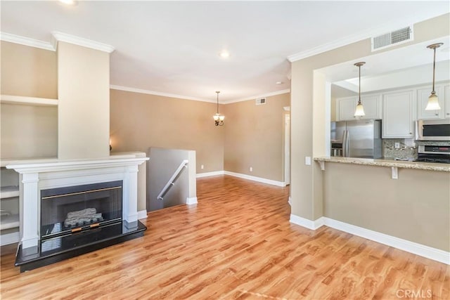 living room with crown molding and light hardwood / wood-style floors