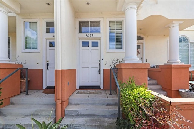 doorway to property featuring stucco siding