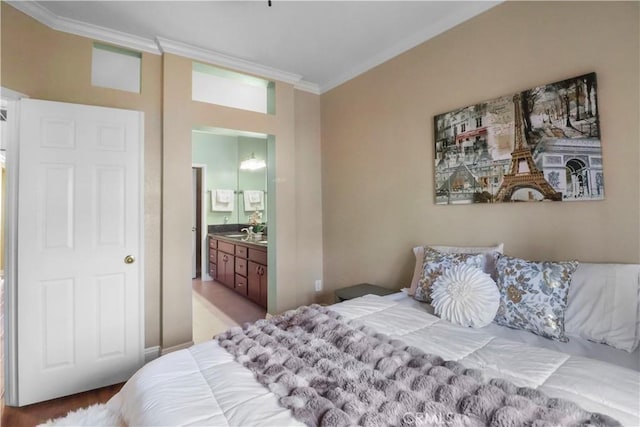 bedroom with a sink, ornamental molding, and ensuite bathroom
