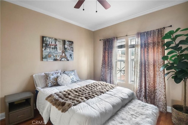 bedroom featuring ceiling fan, baseboards, crown molding, and wood finished floors