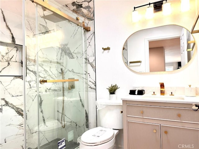 bathroom featuring vanity, a shower with shower door, and toilet