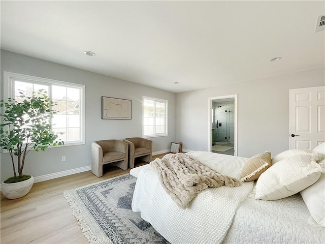 bedroom featuring ensuite bath and light hardwood / wood-style floors