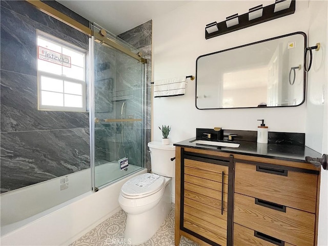 full bathroom with enclosed tub / shower combo, vanity, and toilet