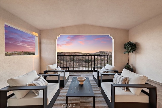 balcony at dusk featuring an outdoor living space