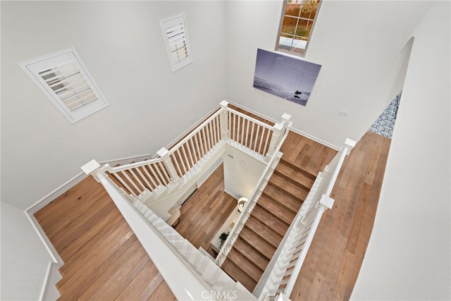 staircase with baseboards and wood finished floors