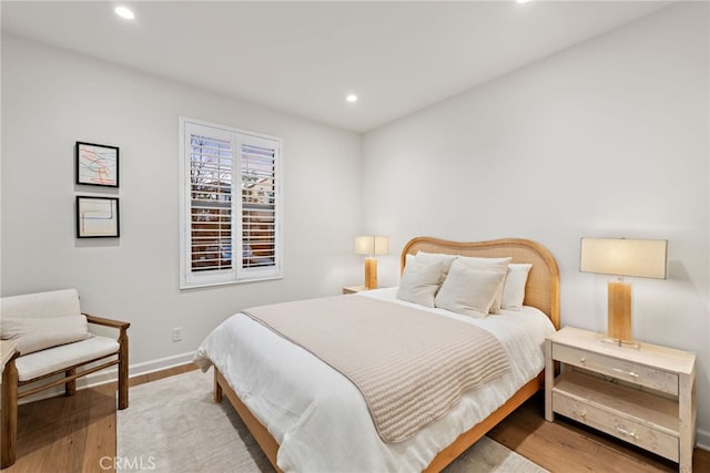 bedroom with baseboards, light wood finished floors, and recessed lighting