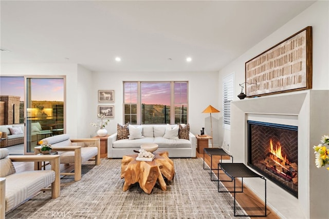 living room featuring a warm lit fireplace and recessed lighting