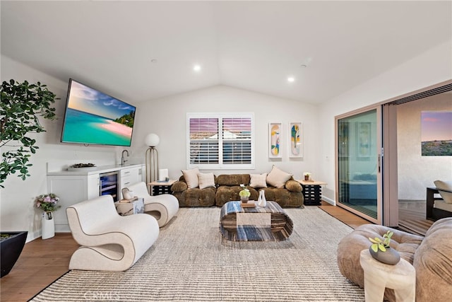 living room with light wood-type flooring, beverage cooler, lofted ceiling, and recessed lighting