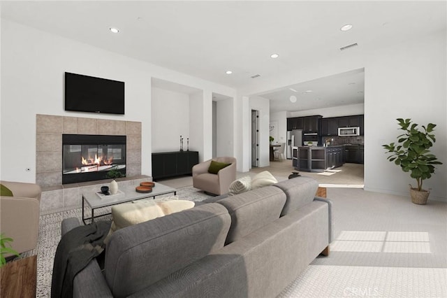 carpeted living room featuring a tile fireplace