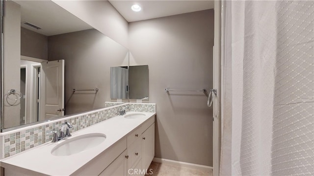 bathroom featuring vanity and backsplash