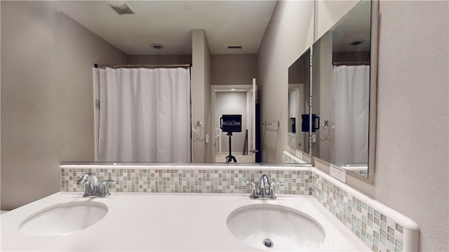 bathroom featuring vanity and decorative backsplash