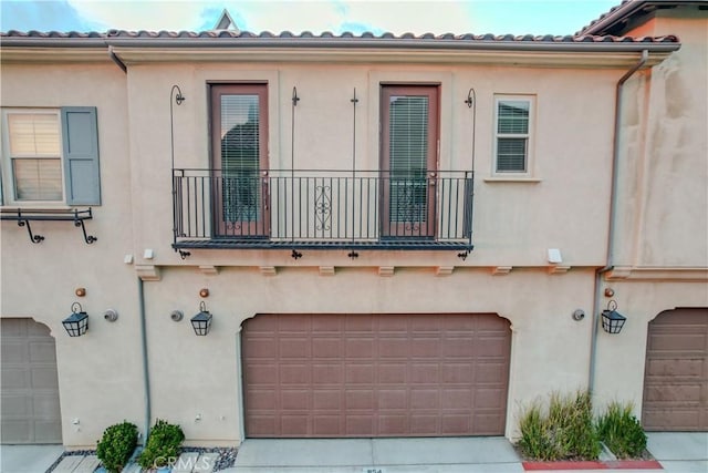 mediterranean / spanish-style home featuring a garage and a balcony