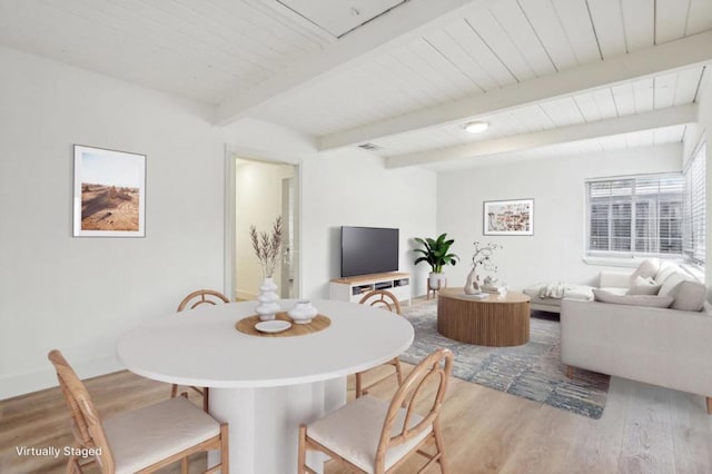 dining area featuring hardwood / wood-style flooring and beam ceiling