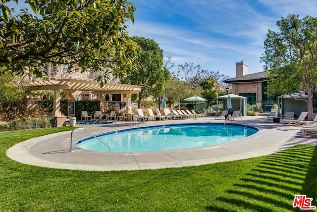 view of swimming pool featuring a yard, a patio area, and a pergola