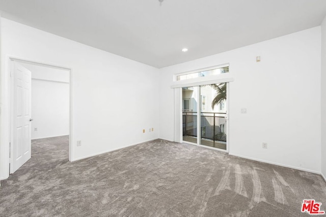 spare room with dark carpet