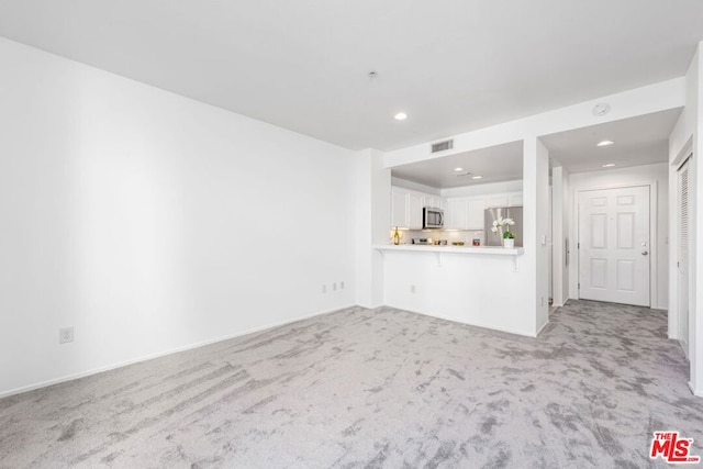 unfurnished living room with light carpet