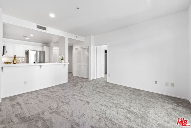 unfurnished living room featuring carpet flooring