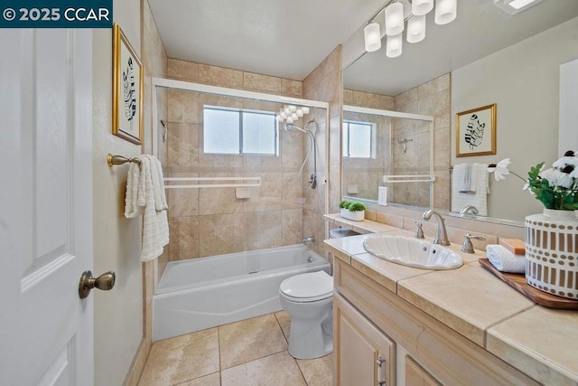 full bathroom featuring vanity, tiled shower / bath combo, tile patterned floors, and toilet