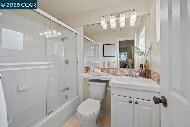 full bathroom featuring vanity, tile patterned floors, shower / bath combination with glass door, and toilet