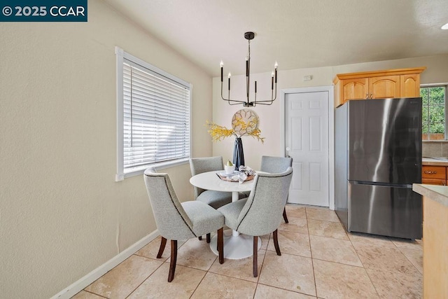 dining area with a wealth of natural light, a chandelier, and light tile patterned flooring