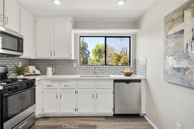 kitchen featuring white cabinetry, sink, tasteful backsplash, and appliances with stainless steel finishes