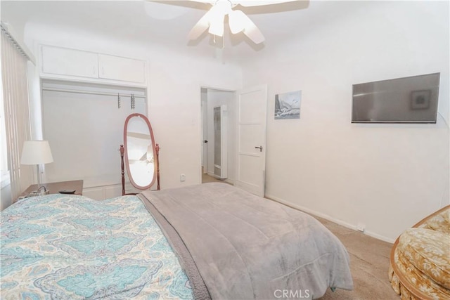 carpeted bedroom with ceiling fan and a closet