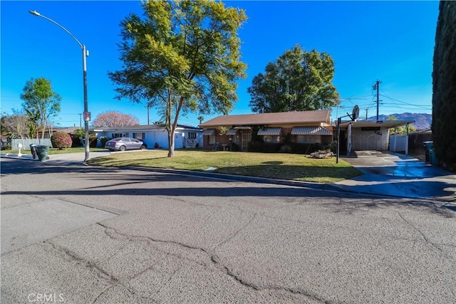 ranch-style home featuring a carport and a front yard