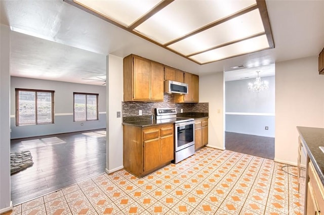 kitchen featuring tasteful backsplash, ceiling fan with notable chandelier, and appliances with stainless steel finishes