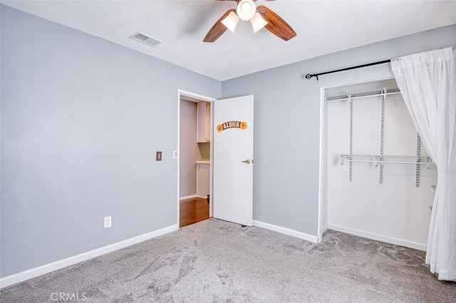 unfurnished bedroom with ceiling fan, light colored carpet, and a closet