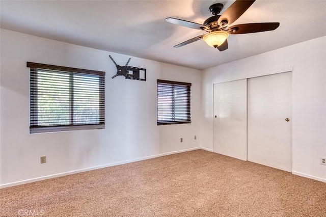 unfurnished bedroom featuring carpet, ceiling fan, and a closet