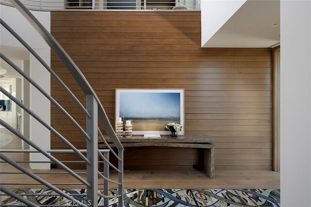 staircase featuring wood walls