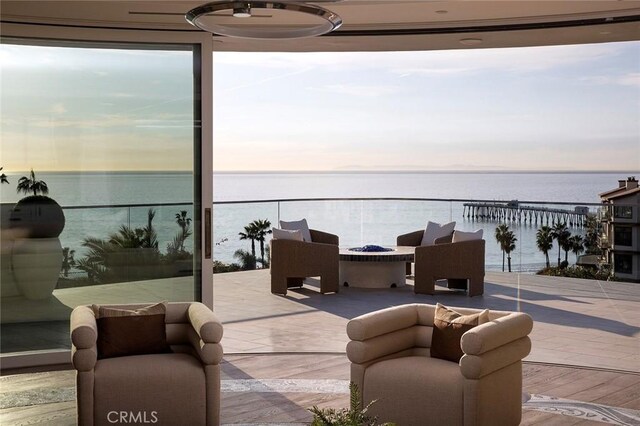 patio terrace at dusk featuring a water view