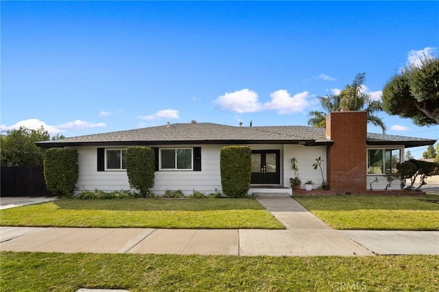 ranch-style home featuring french doors and a front lawn