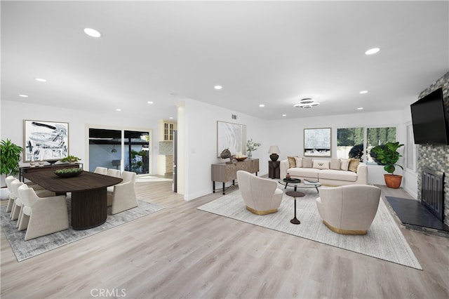 living room with light wood-type flooring and a fireplace