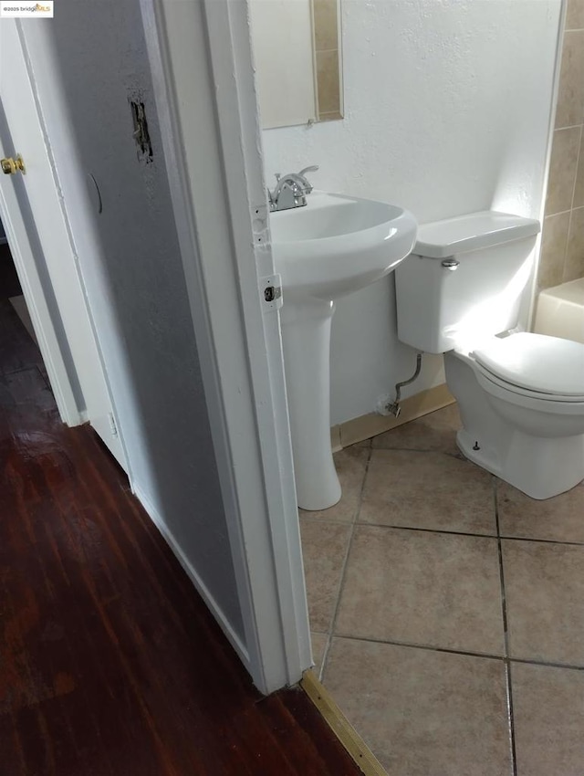 bathroom featuring tile patterned flooring, a bathtub, and toilet